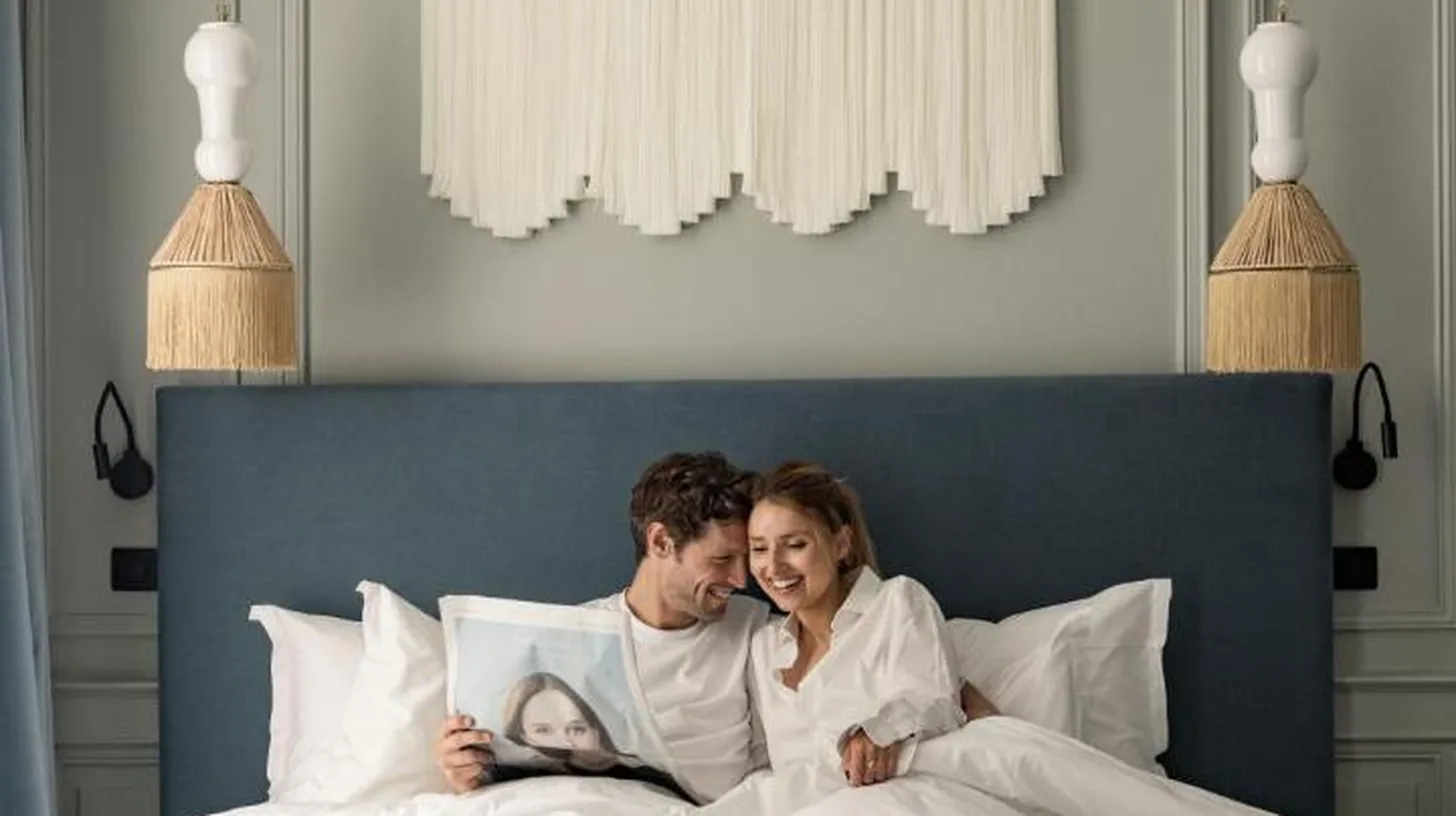a man and a woman laying in bed at Hotel des Quinconces Bordeaux Centre in Bordeaux