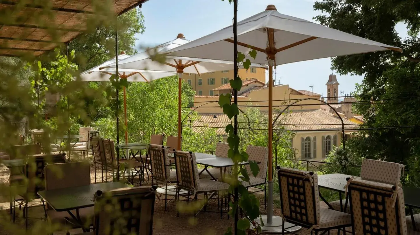 a group of tables and chairs under an umbrella at HÃ´tel du Couvent