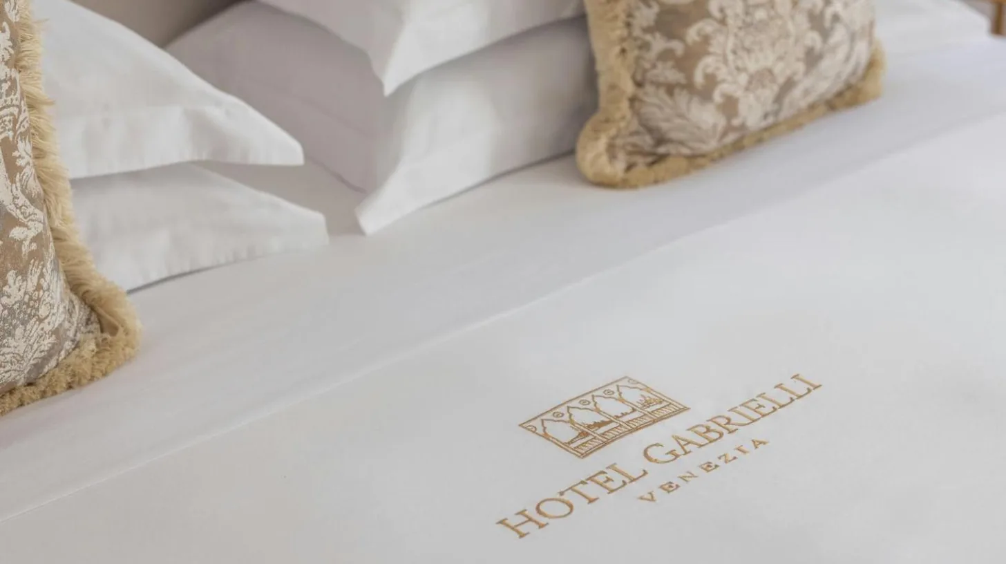gros plan d'un lit avec draps blancs et oreillers Ã  l'Hotel Gabrielli Venezia - Starhotels Collezione Ã  Venise