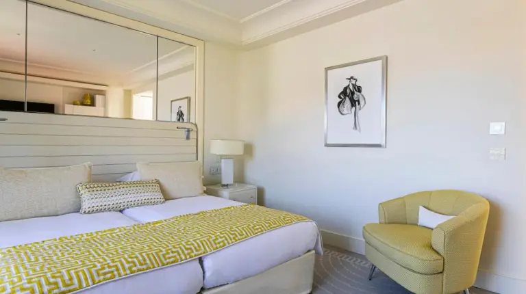 a hotel room with a large bed and a chair at HÃ´tel Martinez