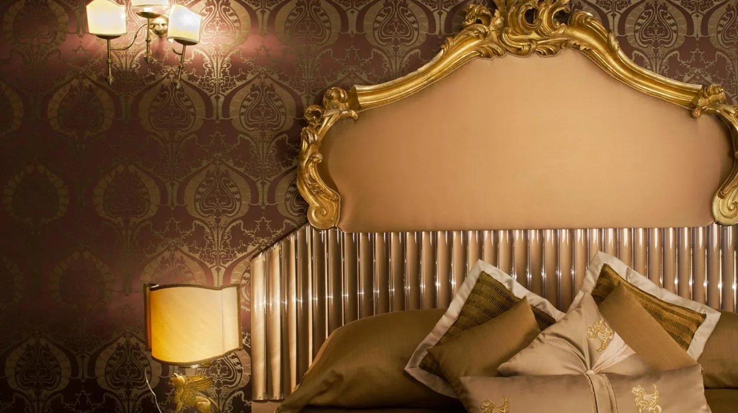 a living room with a bed and a couch and chairs at Hotel Metropole Venezia in Venice