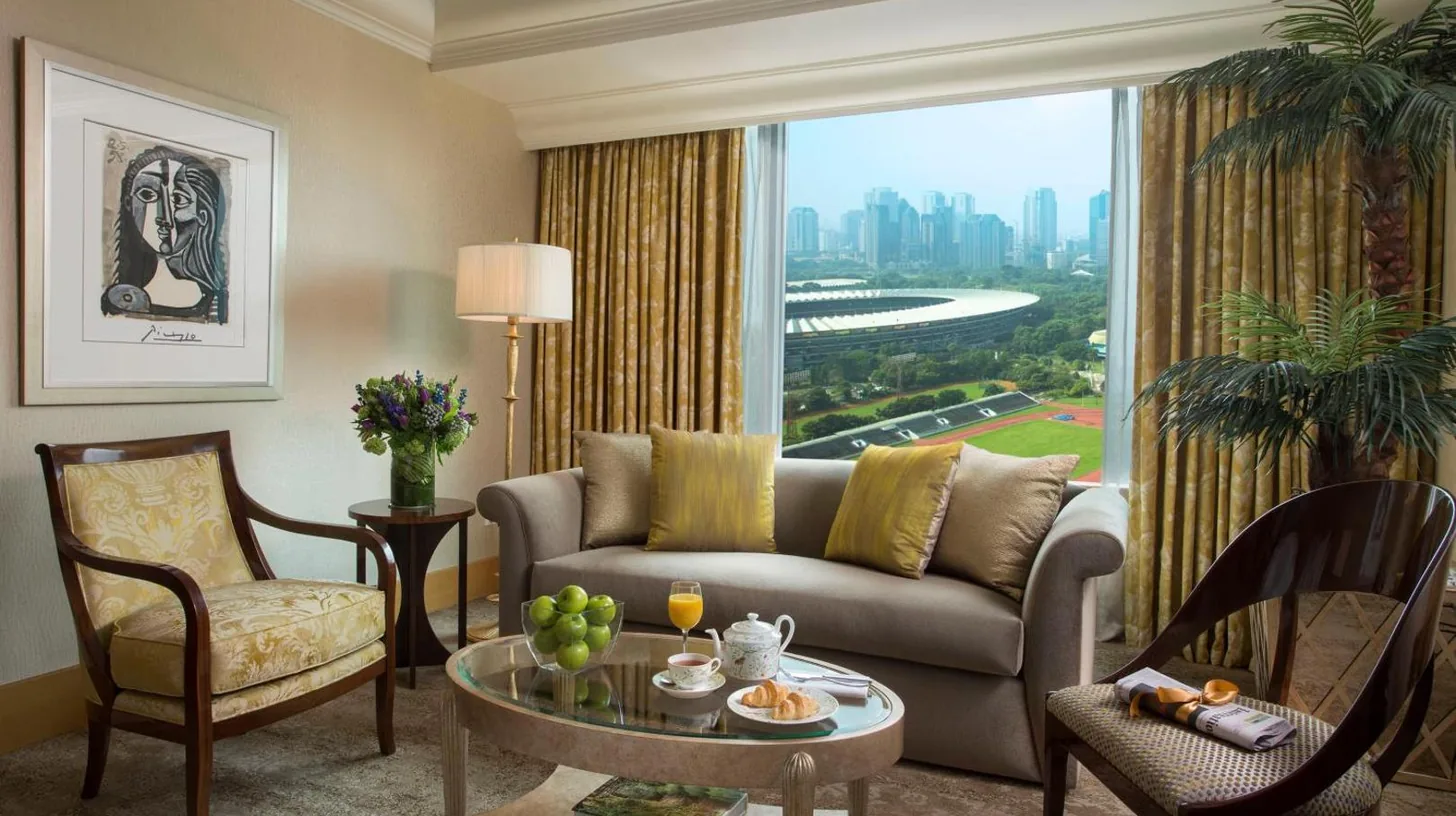 une chambre avec un grand lit et un salon à Hotel Mulia Senayan