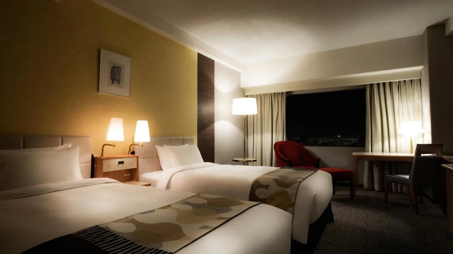 une chambre d'hôtel avec deux lits et un bureau à l'Hotel New Otani Hakata à Fukuoka