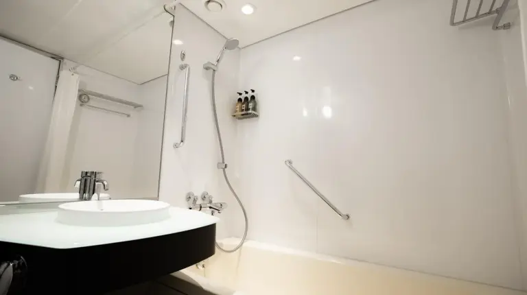 une salle de bain avec un lavabo et une douche à l'Hotel New Otani Hakata à Fukuoka