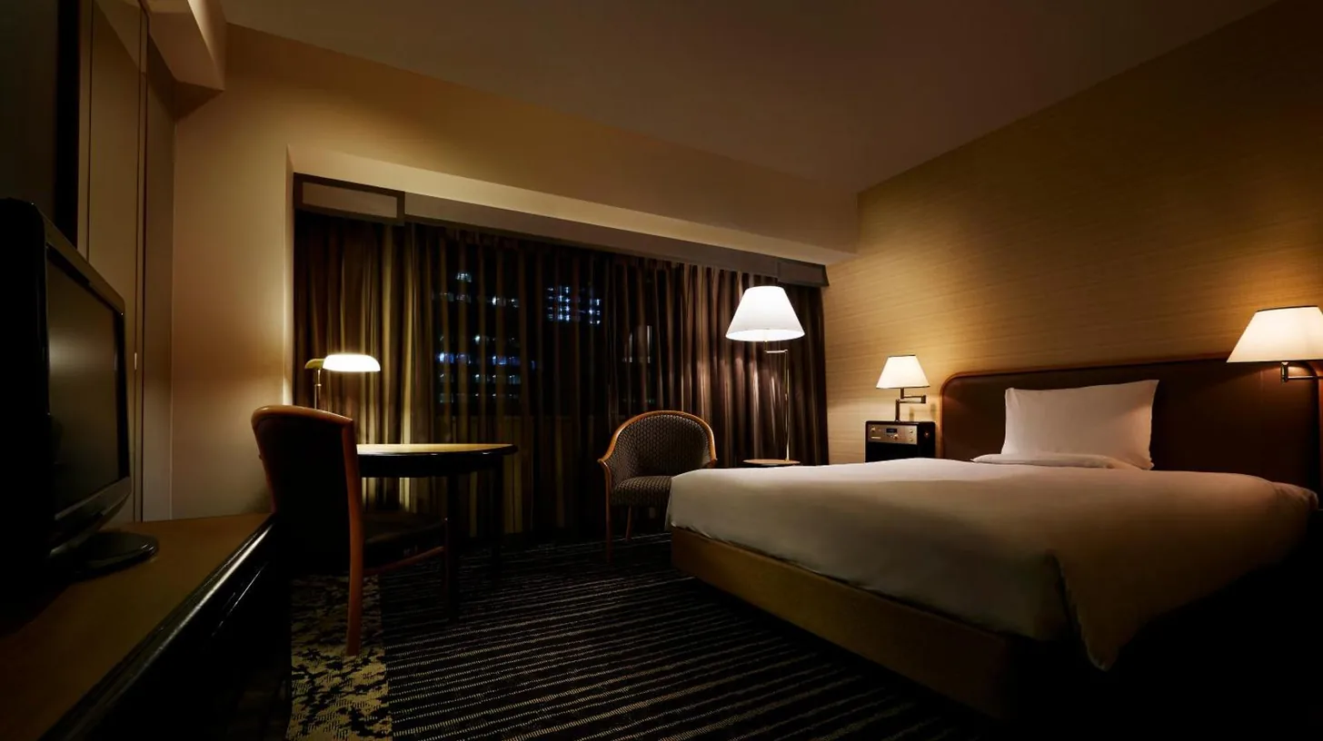 a hotel room with two beds and a window at Hotel New Otani Osaka in Osaka