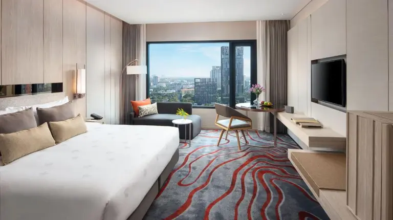 una habitación de hotel con una cama grande y una ventana amplia en Hotel Nikko Bangkok en Bangkok