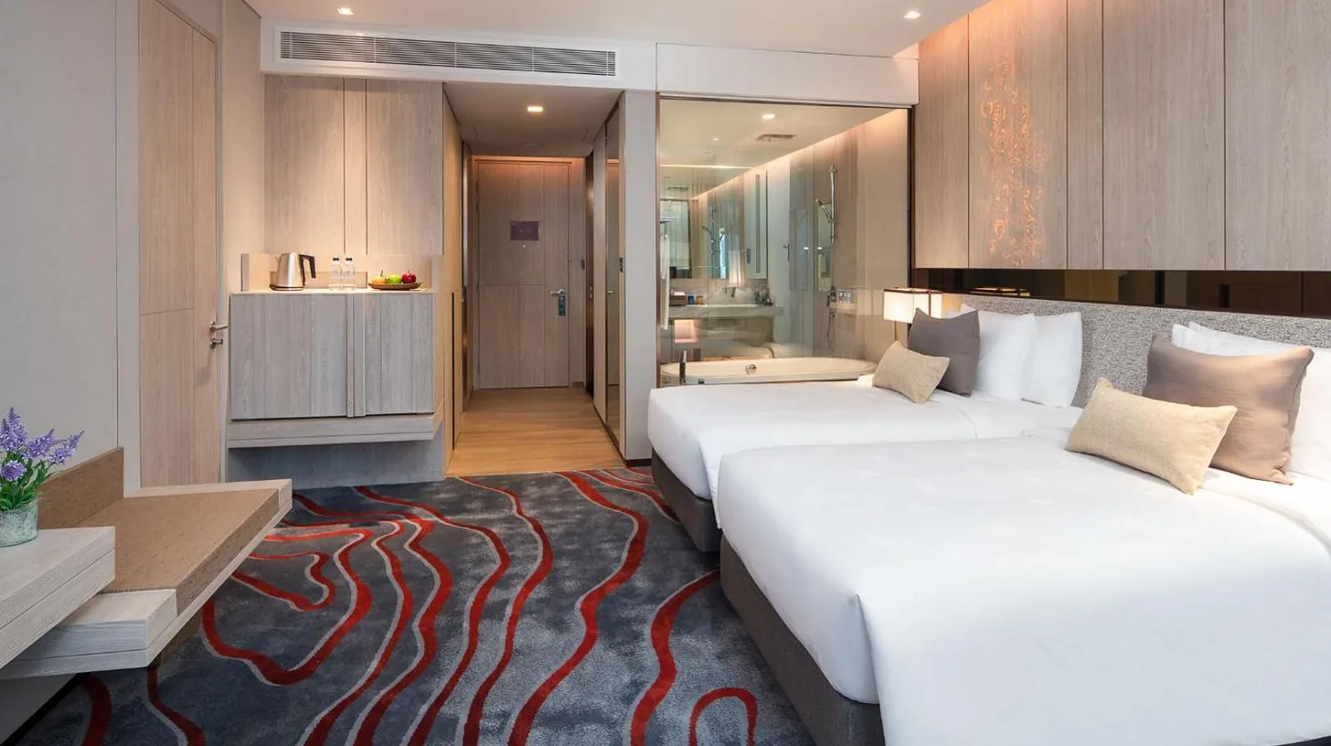 una habitación de hotel con dos camas y un baño en Hotel Nikko Bangkok en Bangkok