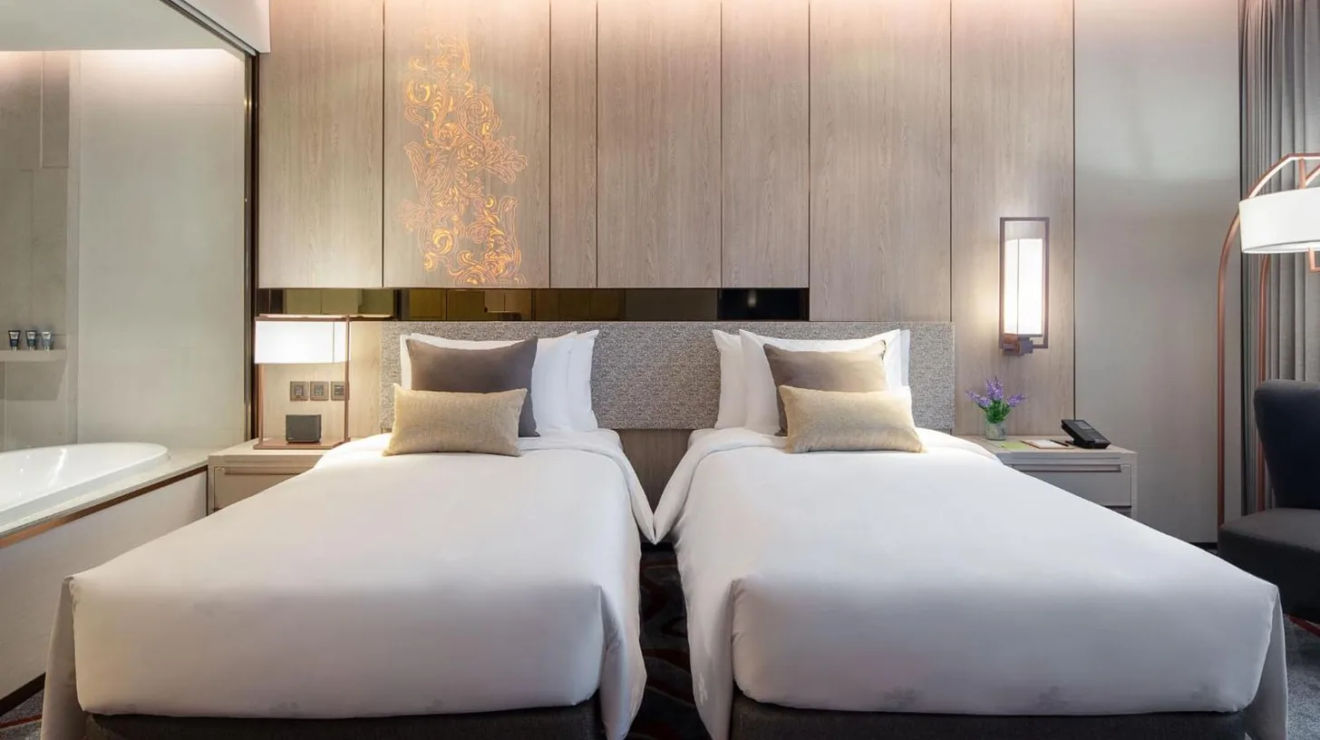 dos camas en una habitación de hotel con baño en Hotel Nikko Bangkok en Bangkok