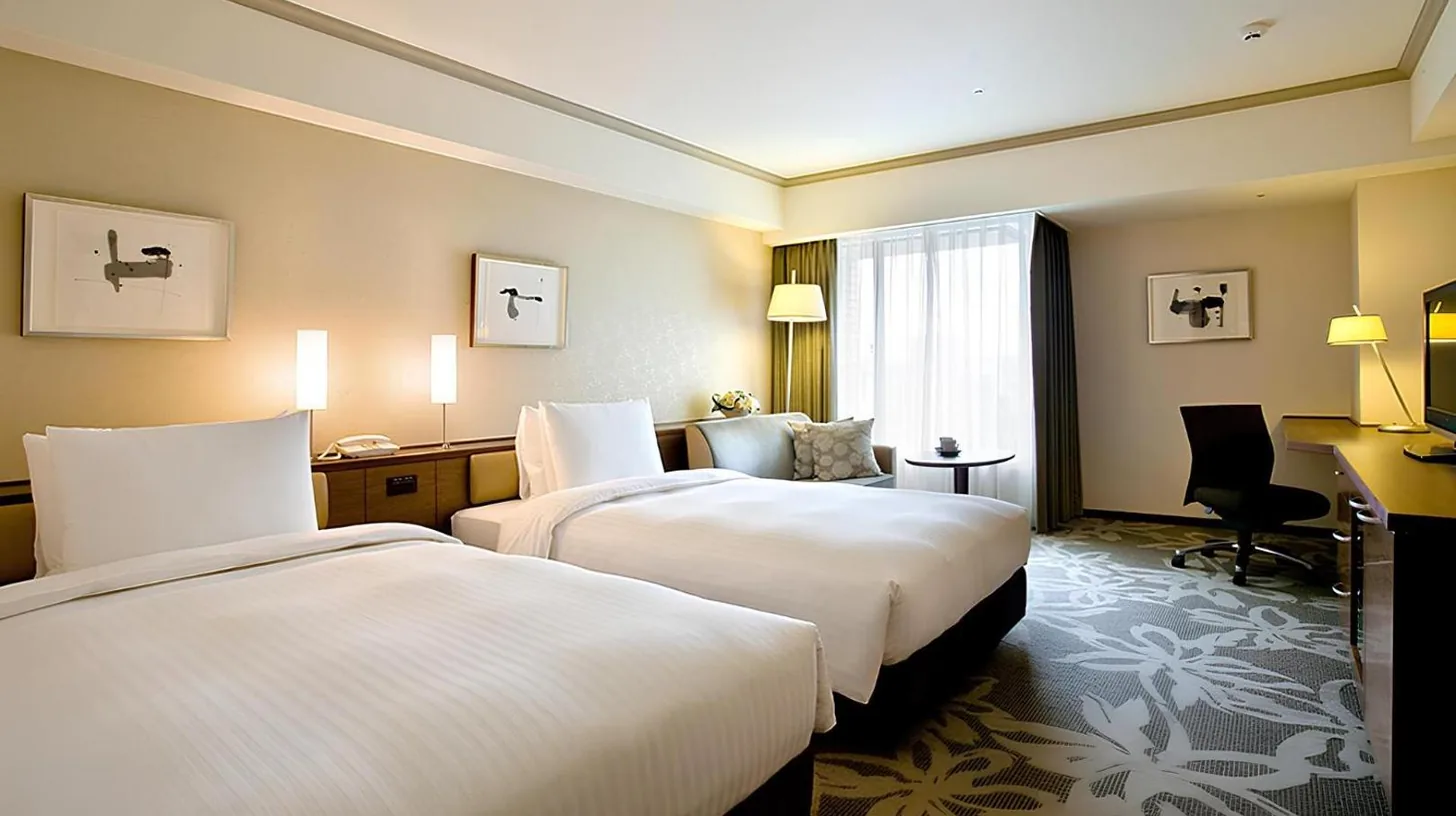 a hotel room with two beds and a couch at Hotel Nikko Fukuoka in Fukuoka