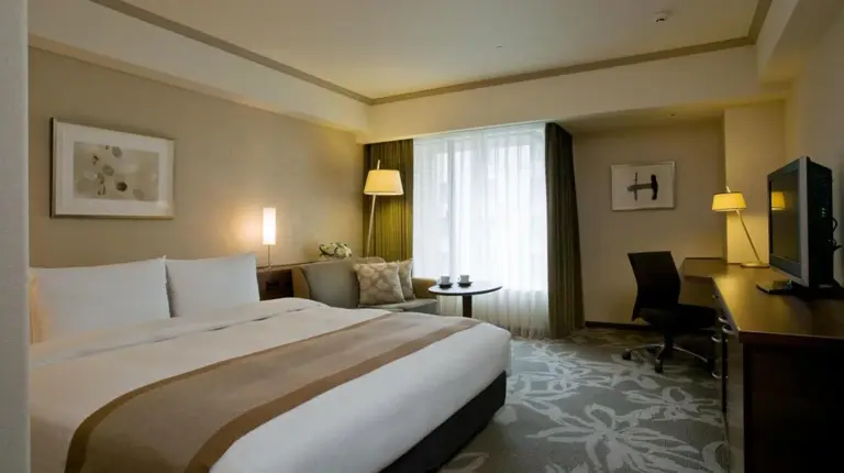 a hotel room with a bed and a television at Hotel Nikko Fukuoka in Fukuoka