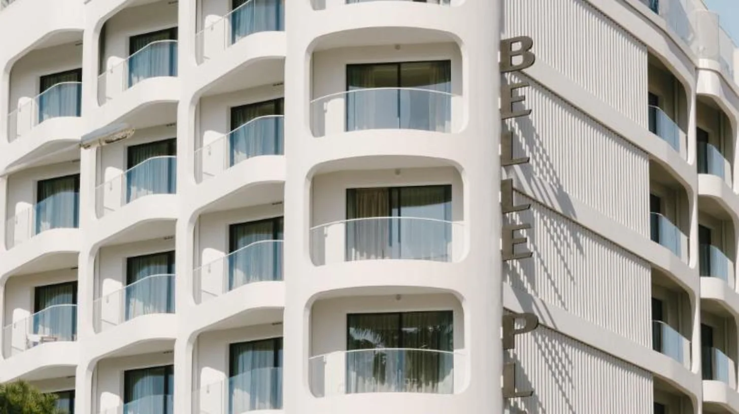 a white apartment building with a white facade at Hôtel & Spa Belle Plage in Cannes