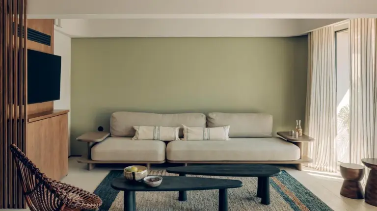 a living room with a couch and a table at Hôtel & Spa Belle Plage in Cannes