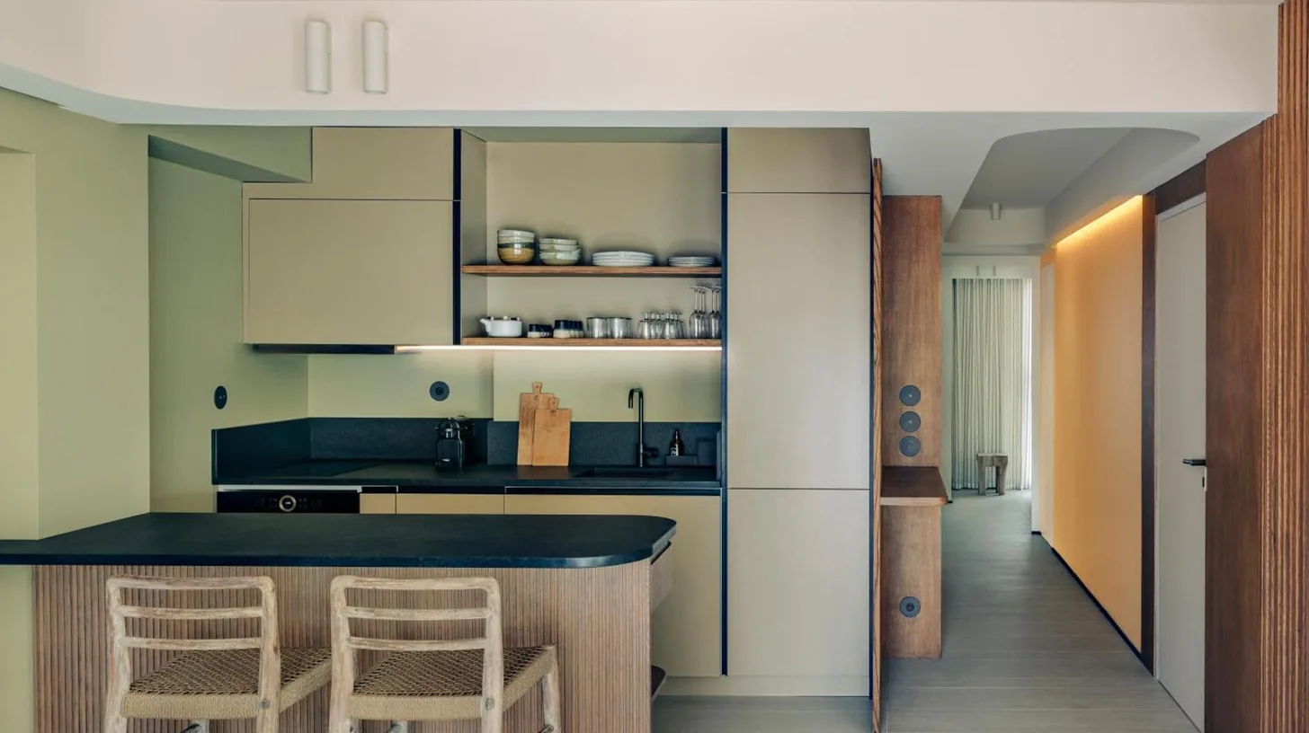 a kitchen with a counter and stools in a room at Hôtel & Spa Belle Plage in Cannes