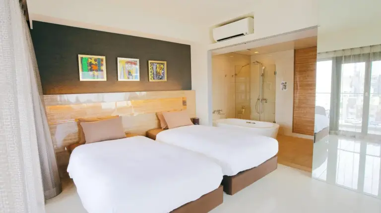 a bedroom with two beds and a bath room at HOTEL Viviana in Naha