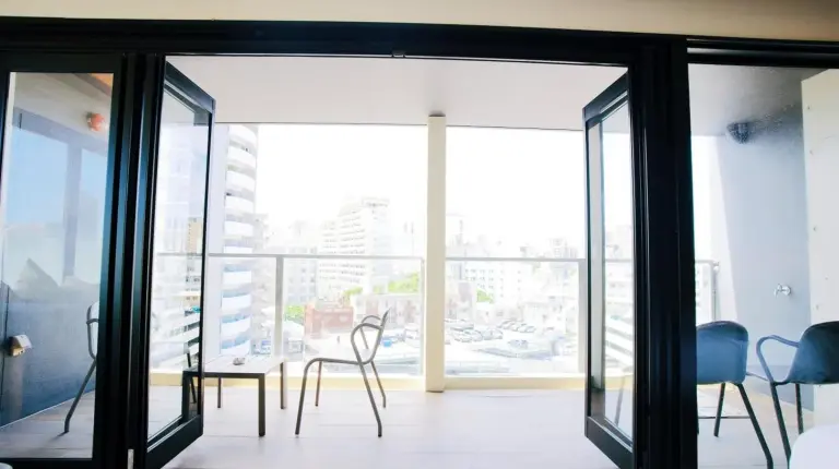 a room with glass doors and a table and chairs at HOTEL Viviana in Naha