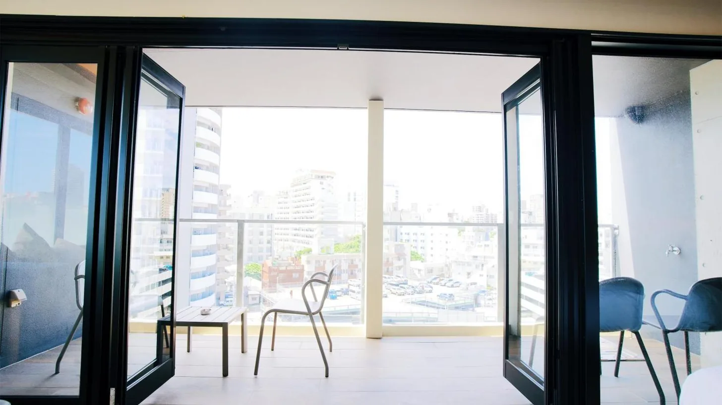 a room with glass doors and a table and chairs at HOTEL Viviana in Naha