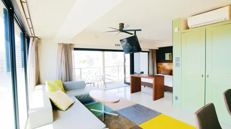 a hotel room with a bed and a bathroom at HOTEL Viviana in Naha