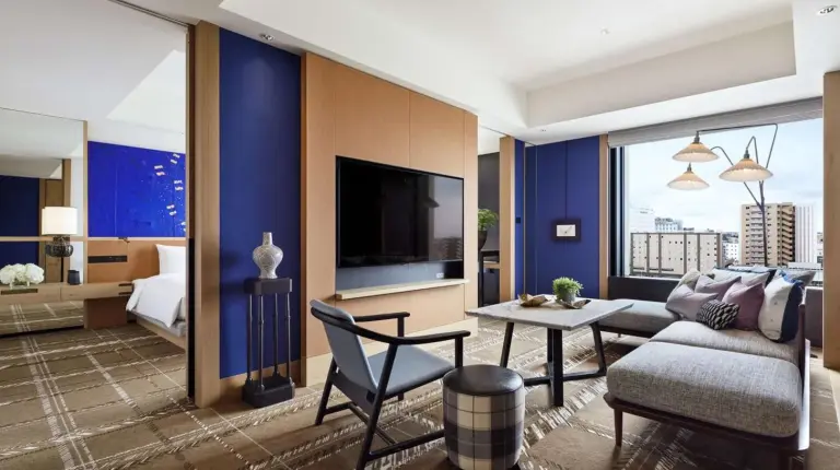 a living room with a couch and a table and a tv at Hyatt Centric Kanazawa in Kanazawa