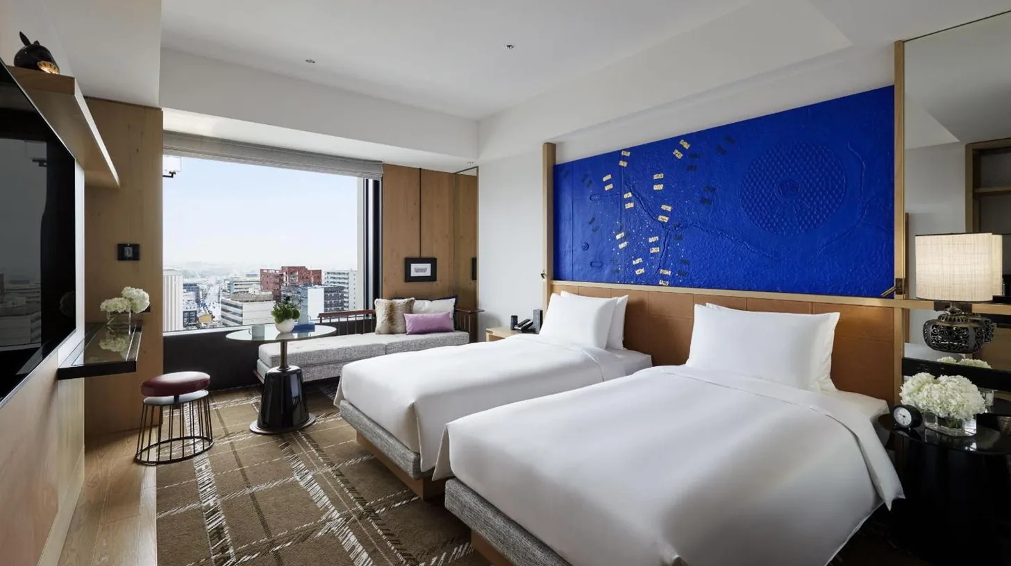 a hotel room with two beds and a couch at Hyatt Centric Kanazawa in Kanazawa