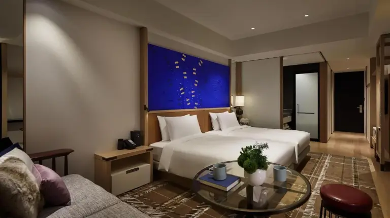 a hotel room with a bed and a glass table at Hyatt Centric Kanazawa in Kanazawa