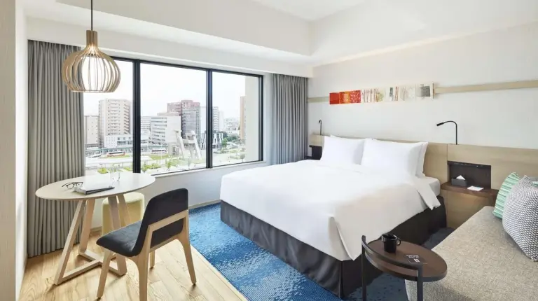 a hotel room with a bed and a desk and a couch at Hyatt House Kanazawa in Kanazawa