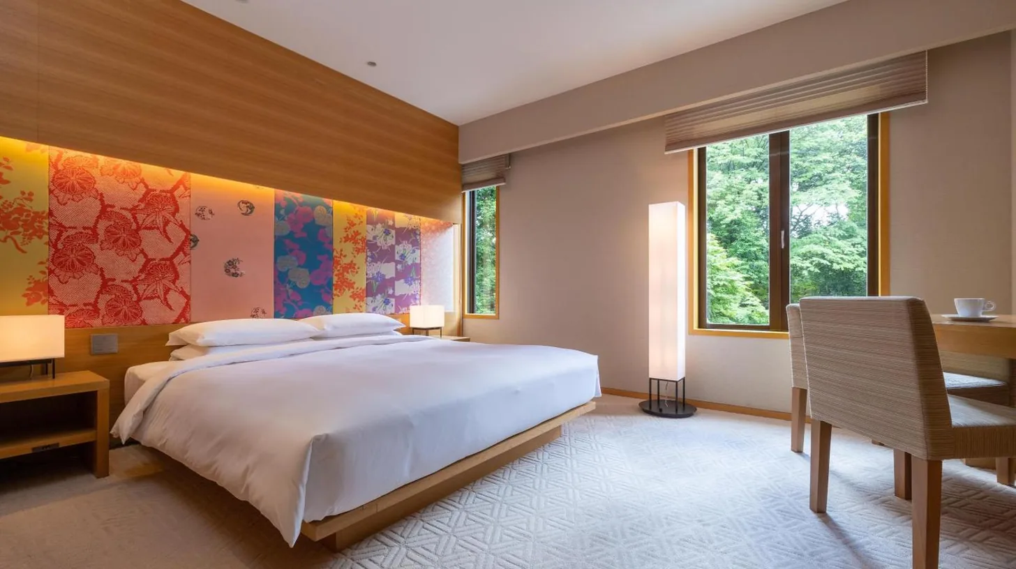 a bedroom with a large white bed and a desk at Hyatt Regency Kyoto in Kyoto
