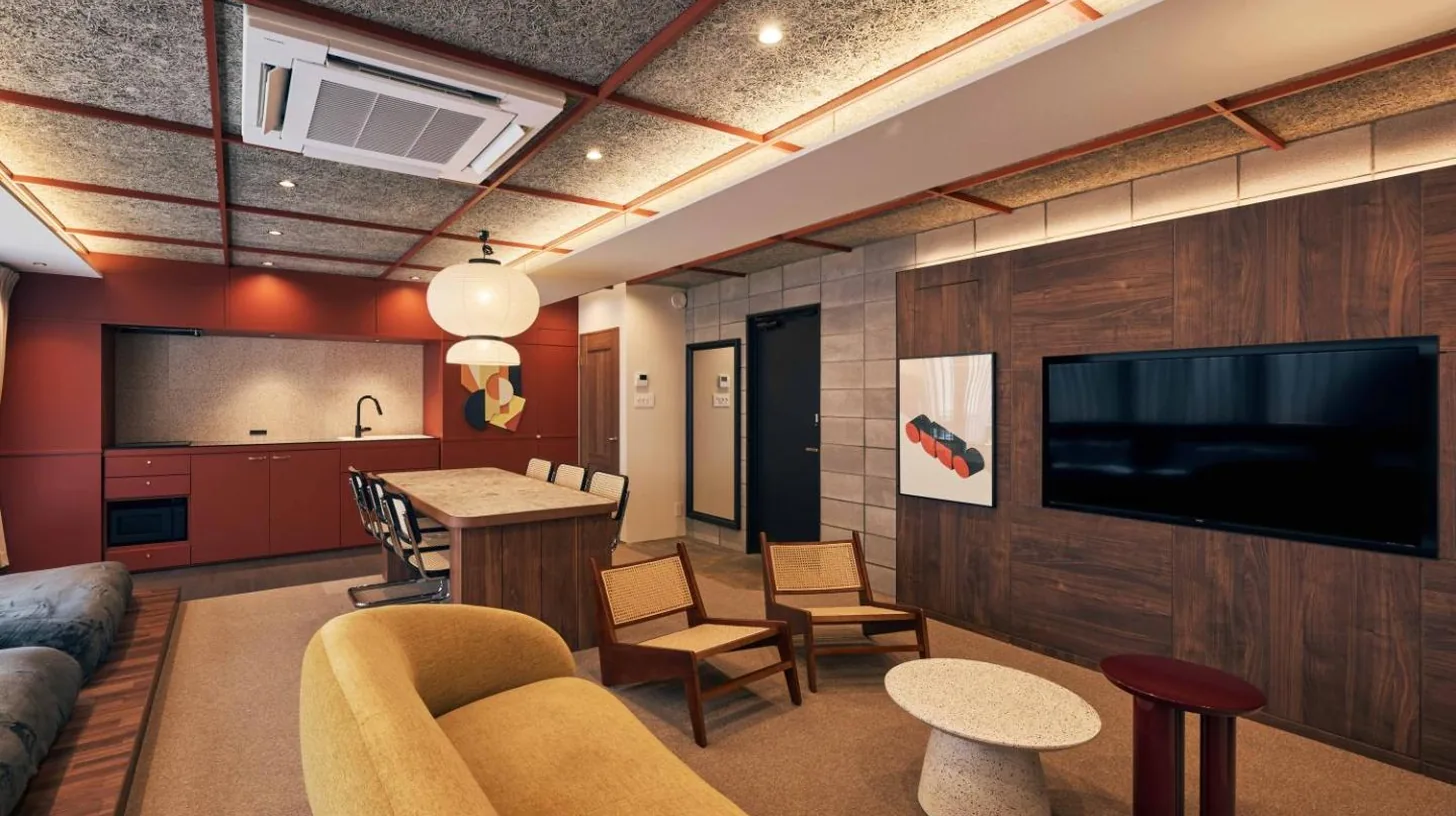a hotel room with four beds and a table at illi Jam Shinsaibashi in Osaka