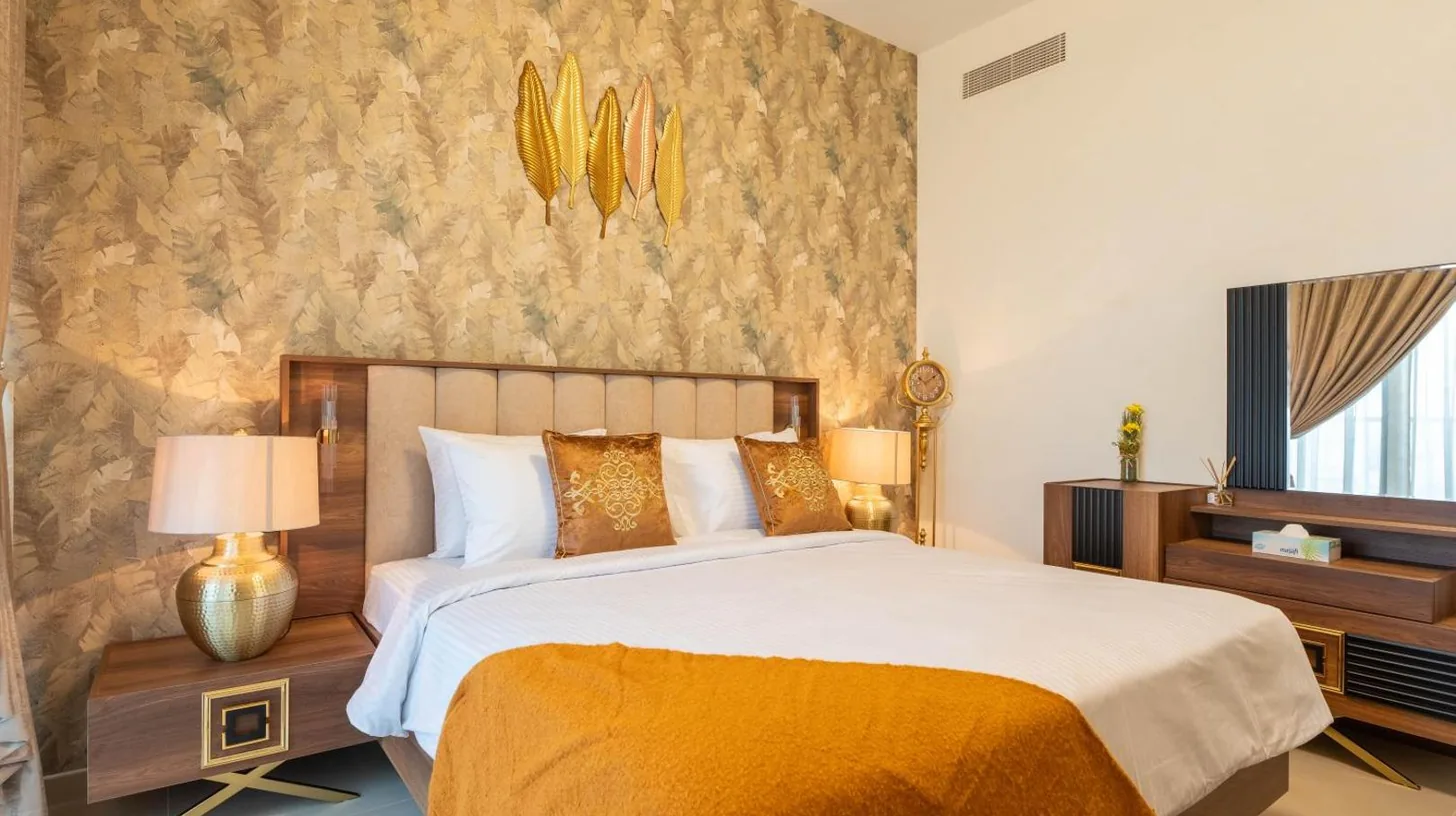 a bedroom with a large bed with a yellow blanket at INA Homes - Act 1 Full Burj Khalifa and Fountain Views in Dubai