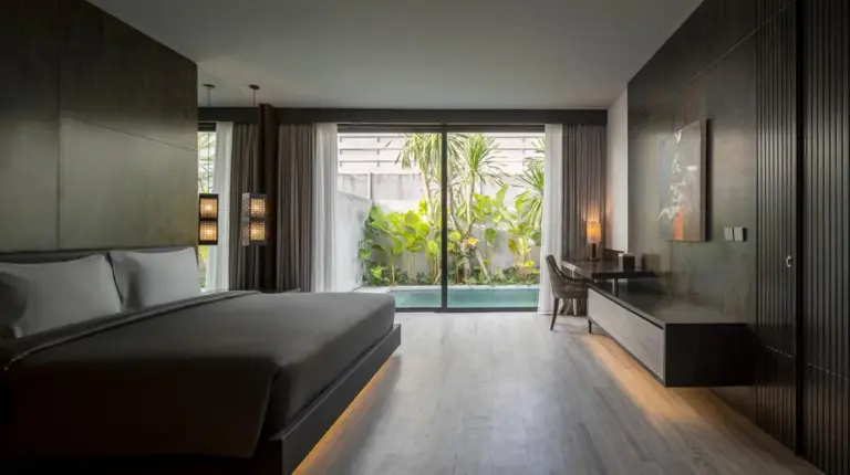 une chambre avec un lit, un bureau et une fenêtre à INSPIRA Seminyak à Seminyak