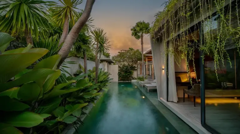 une piscine au milieu d’une maison avec des palmiers à INSPIRA Seminyak à Seminyak