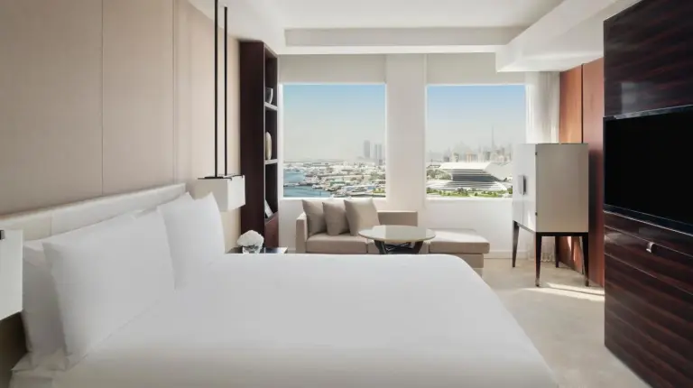 a bedroom with a white bed and a living room at InterContinental Dubai Festival City by IHG in Dubai