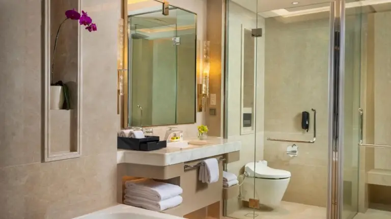 a bedroom with a large white bed and a chair at InterContinental Hotels Jakarta Pondok Indah by IHG in Jakarta