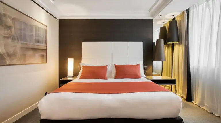 a bedroom with a large bed with red pillows at InterContinental Marseille - Hotel Dieu by IHG in Marseille