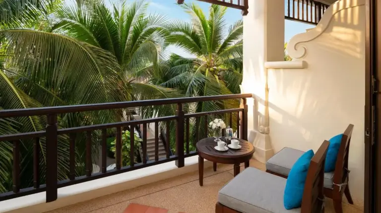 ein Balkon mit Tisch, Stühlen und Palmen im InterContinental Pattaya Resort von IHG in Süd‑Pattaya