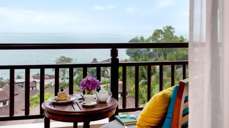 ein Tisch und Stuhl auf einem Balkon mit Blick auf den Ozean im InterContinental Pattaya Resort von IHG in Süd‑Pattaya
