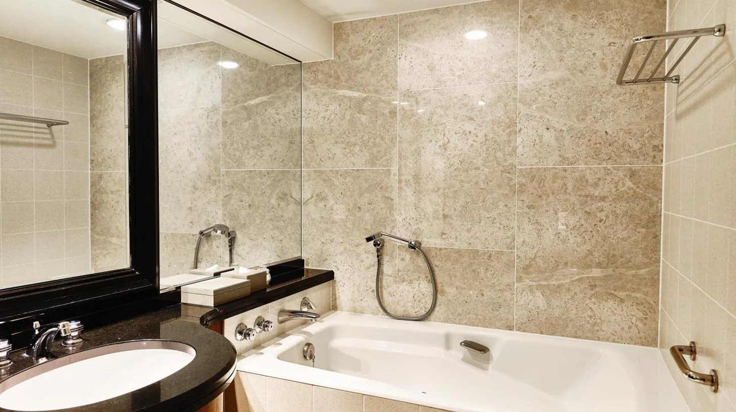 a bathroom with a tub and a sink and a mirror at InterContinental Tokyo Bay by IHG in Tokyo