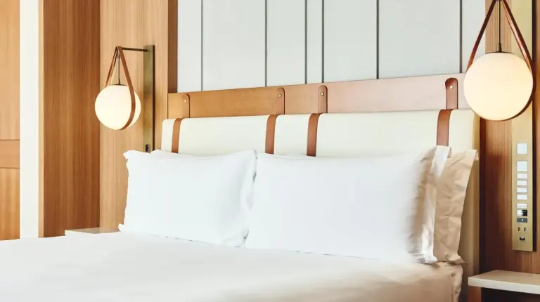 a bedroom with a bed with white pillows and two lights at InterContinental Yokohama Pier 8 by IHG in Yokohama
