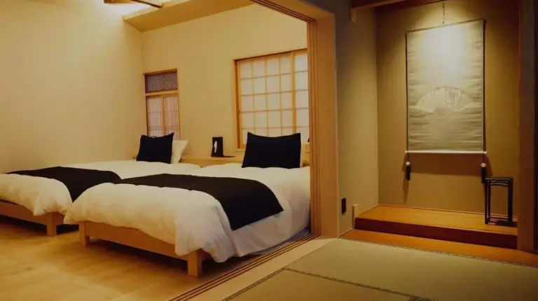 une chambre avec deux lits et une fenêtre à Ishibekoji Muan à Kyoto