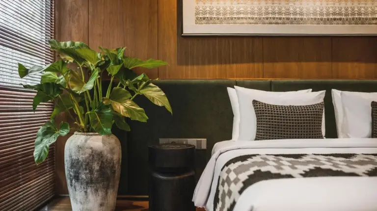a bedroom with a bed and a vase with a plant at iSuite by Ekosistem in Seminyak