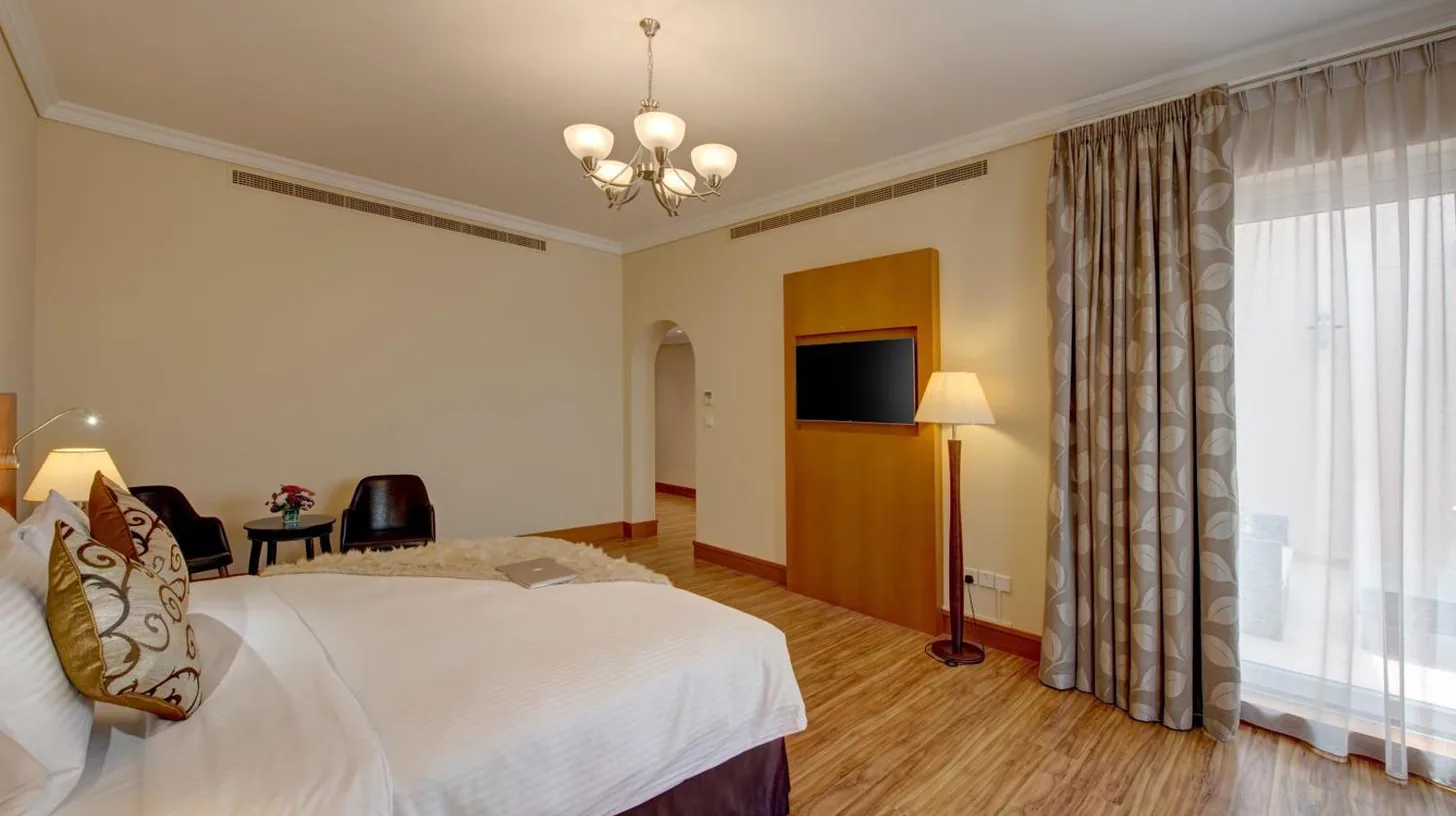 a hotel room with a bed and a television at J5 Villas Holiday Homes Barsha Gardens in Dubai
