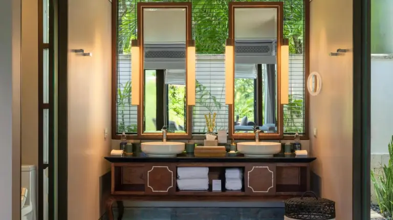 a dining room with tables and chairs and windows at Jumeirah Bali in Uluwatu