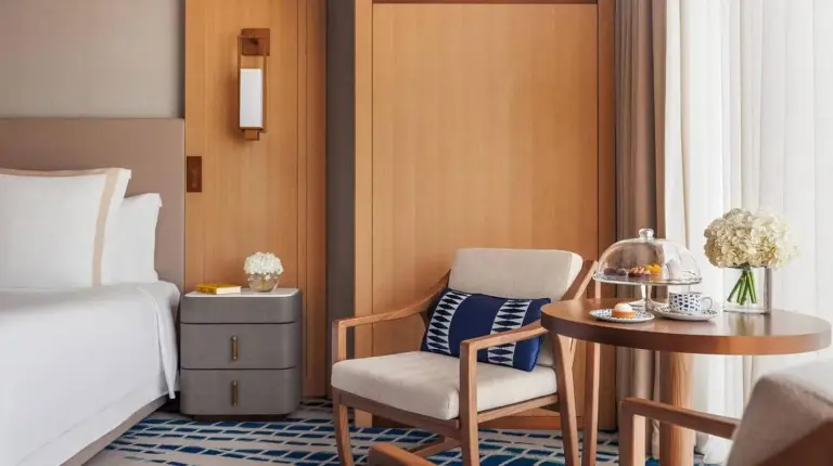 a hotel room with a bed and a table and chair at Jumeirah Beach Hotel Dubai in Dubai