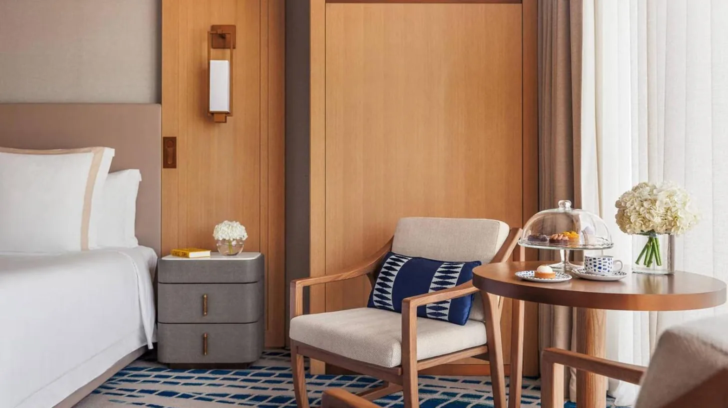 a hotel room with a bed and a table and chair at Jumeirah Beach Hotel Dubai in Dubai