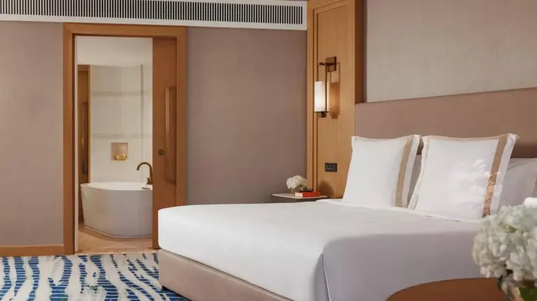 a bedroom with a large bed and a bath tub at Jumeirah Beach Hotel Dubai in Dubai