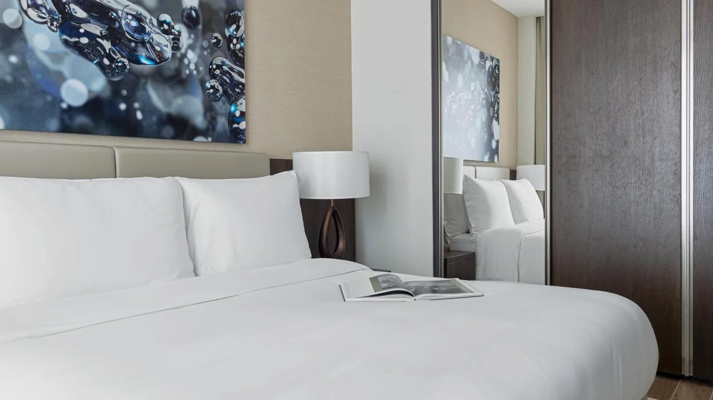 a bedroom with a white bed with a book on it at Jumeirah Living Marina Gate in Dubai