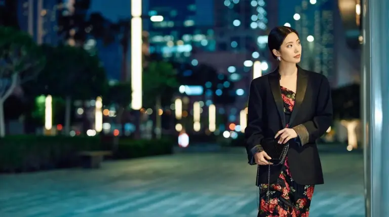 a woman standing on a city street at night at Jumeirah Living Marina Gate in Dubai