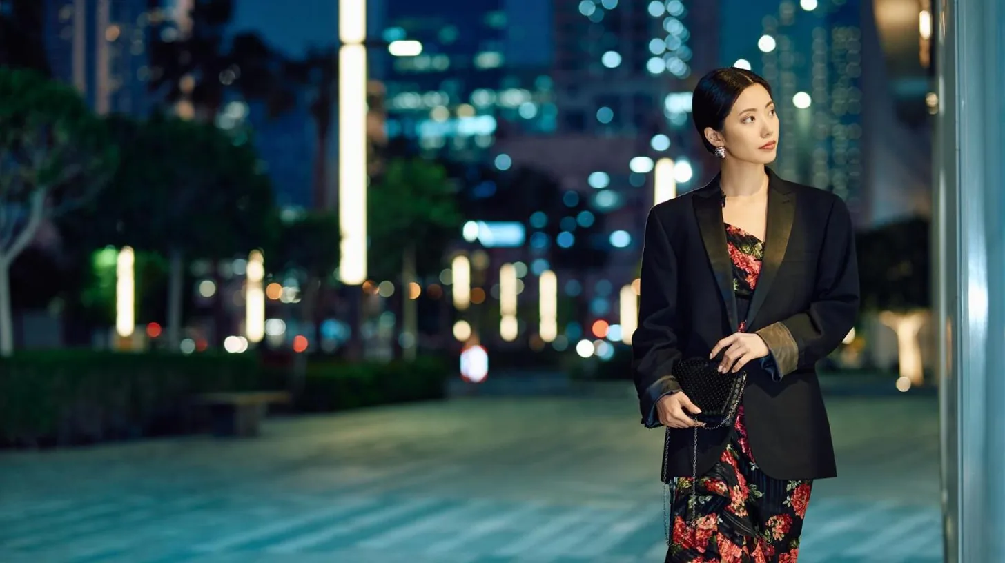 a woman standing on a city street at night at Jumeirah Living Marina Gate in Dubai