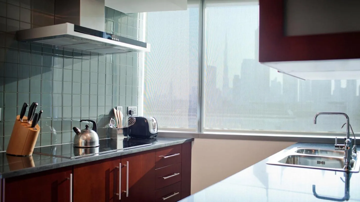 a kitchen with wooden cabinets and a large window at Jumeirah Living World Trade Centre Dubai in Dubai