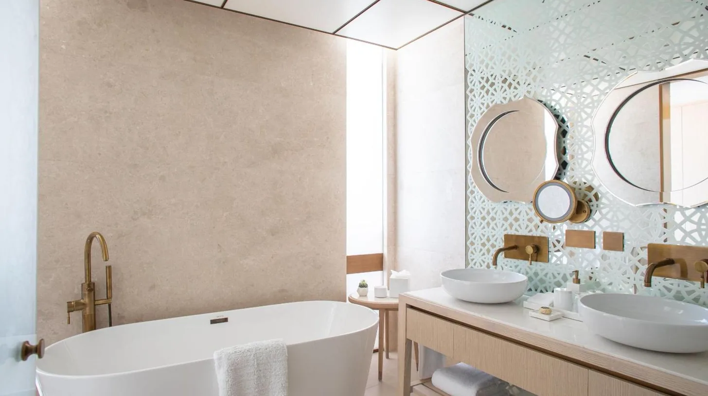 a bathroom with two sinks and a tub and mirrors at Jumeirah Saadiyat Island Abu Dhabi in Abu Dhabi