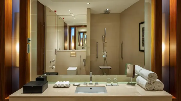 a bathroom with a sink and a large mirror at JW Marriott Marquis Hotel Dubai in Dubai